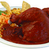 The pollo en mole is half a chicken smothered in a homemade mole, accompanied by rice, beans, and your choice of tortillas.